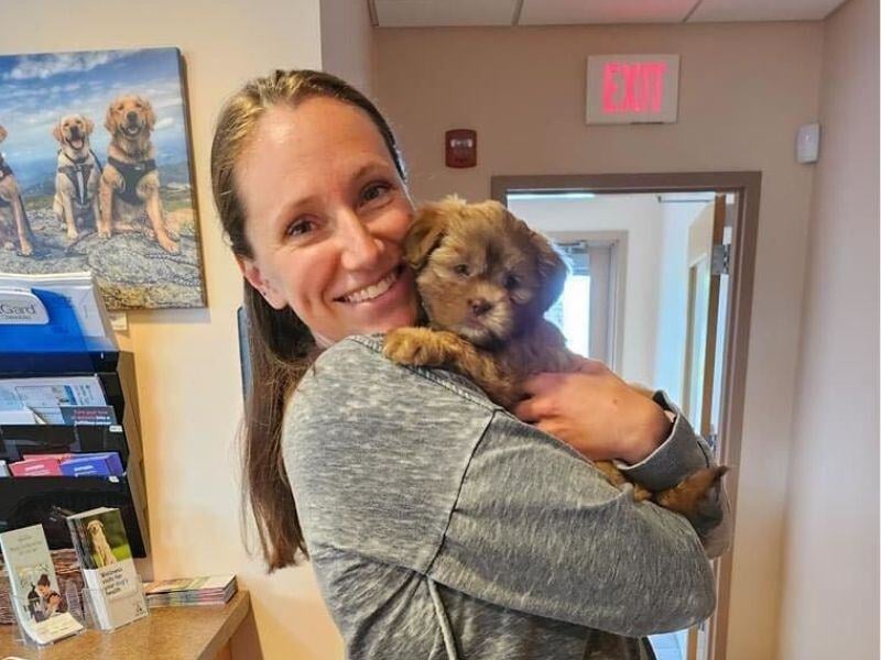 Veterinarian-holding-puppy